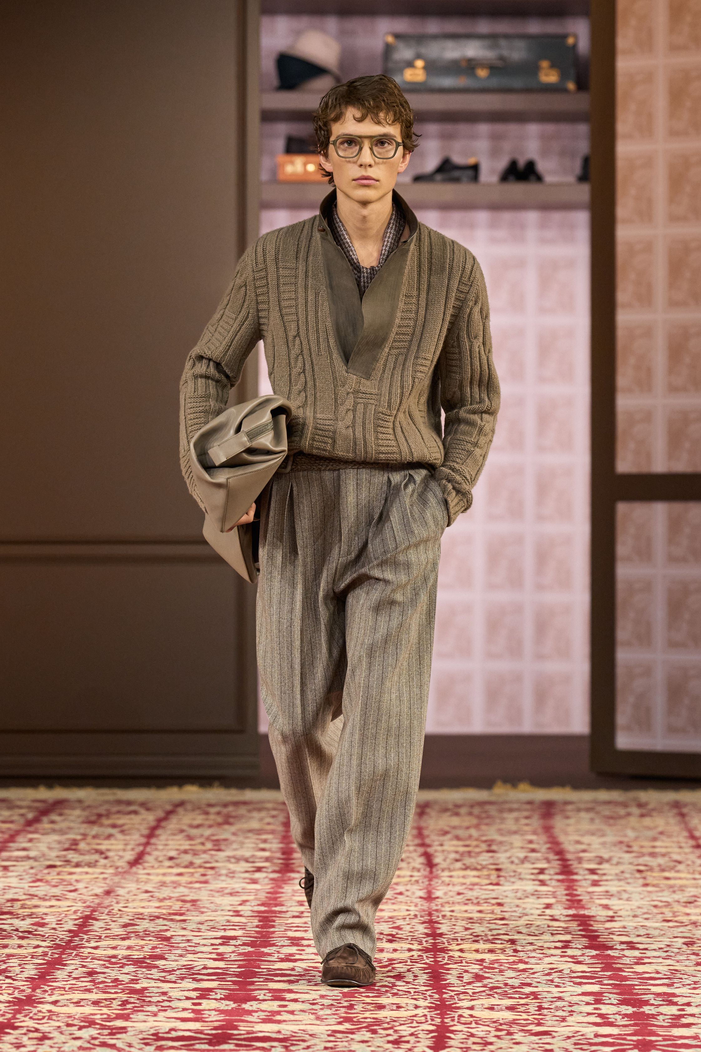 ZEGNA 2026秋冬以“安静权威”为核心命题，在高度私密、近乎沙龙式的空间中重塑当代男性精英形象。柔和灯光下，西装、大衣与针织被处理得异常克制，廓形松弛却精准，强调肩线的自然下垂与裤装的流动垂感。羊毛、羊绒与精纺面料成为绝对主角，色彩集中于驼色、烟灰、深橄榄与夜黑，传递一种无需证明的自信。这一季ZEGNA不谈趋势，而是提出一种长期有效的男性着装秩序——成熟、内敛、经得起时间审视的“当代绅士体系”-顽石频道趋势研究